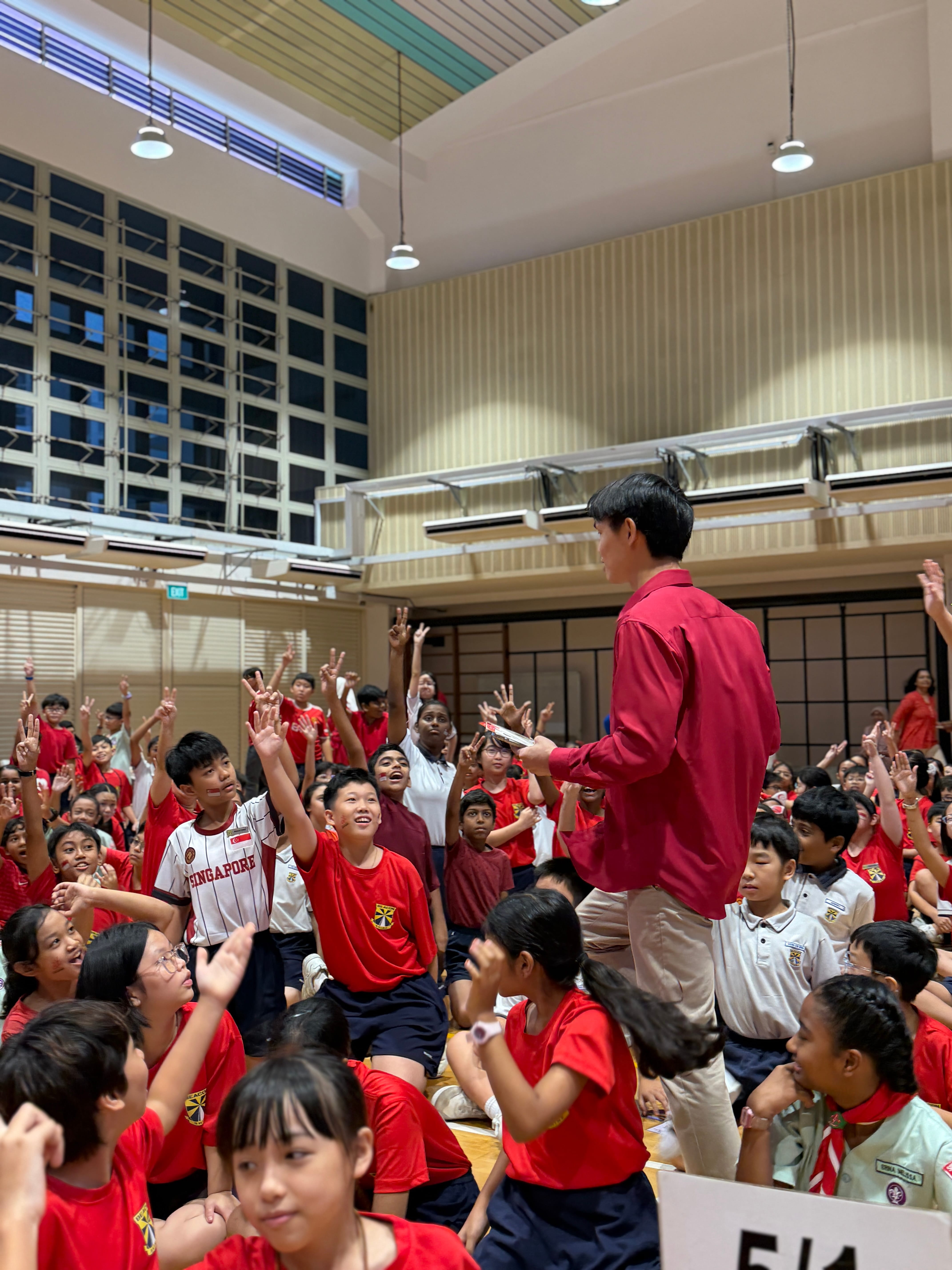 🙋‍♂️ Fastest Fingers First: The school hall buzzes with excitement as students race to answer questions about Singapore during the high-energy National Day trivia challenge.